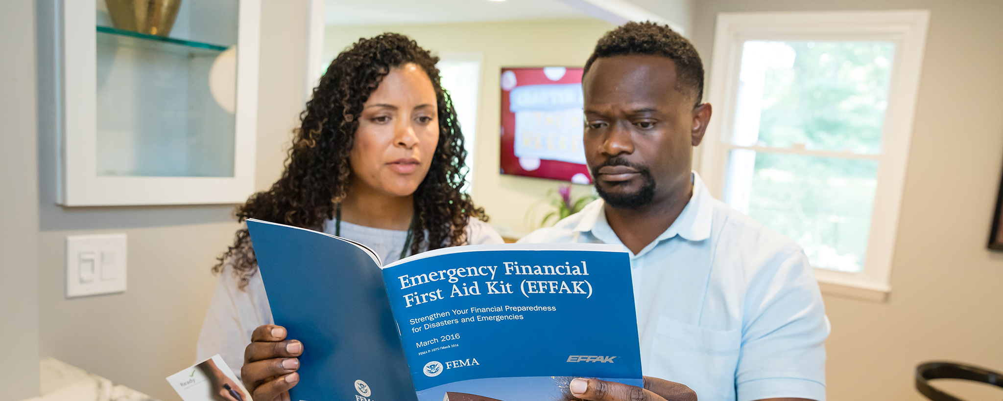 a couple looks at an Emergency Financial First Aid Kit