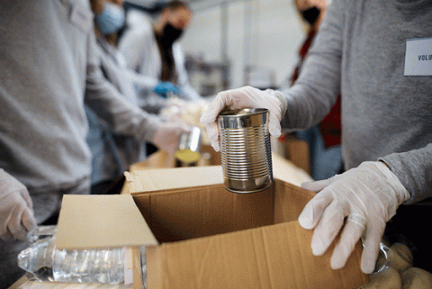 Volunteers packing boxes with water and canned goods.