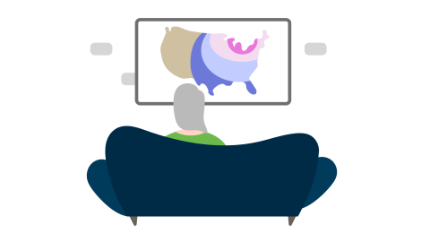 A woman sitting on a couch watching the weather report on tv. 