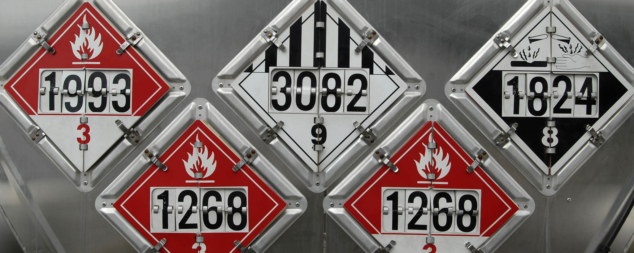 Five different hazardous materials signs showing different numbers and warnings