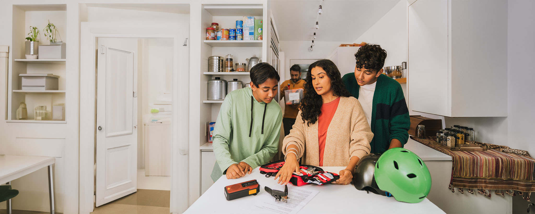 A family of south Asian decent build an emergency supply kit in their kitchen. 