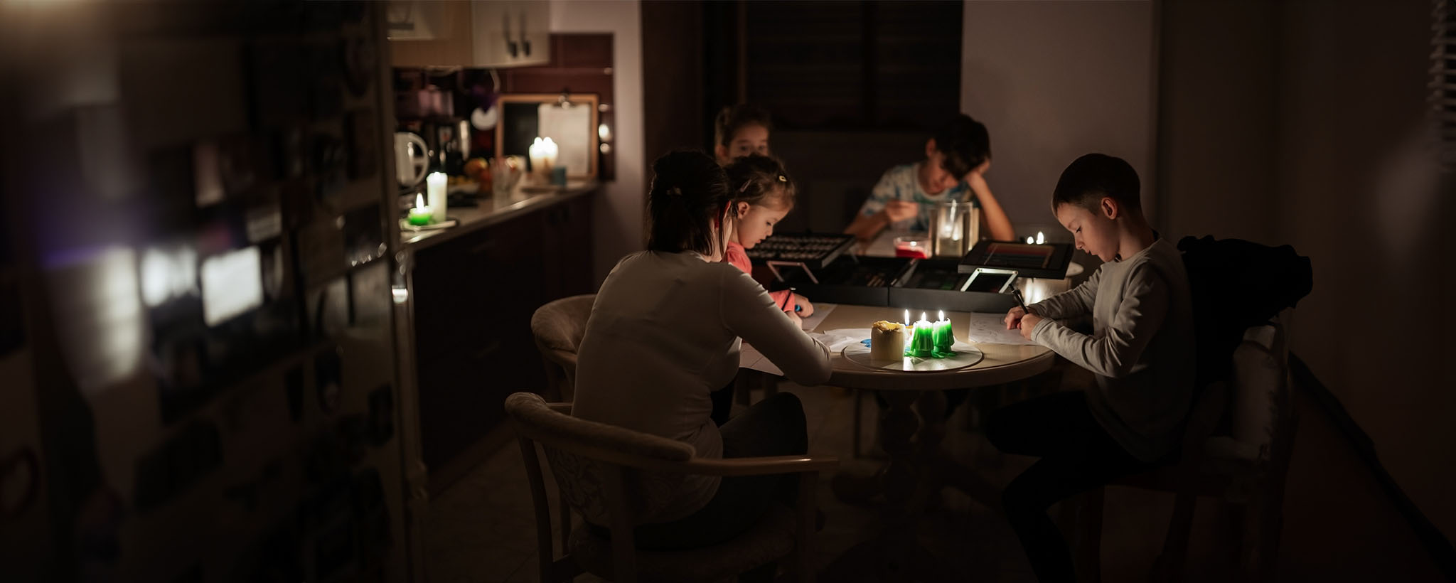 A family plays games and draws during a power outage